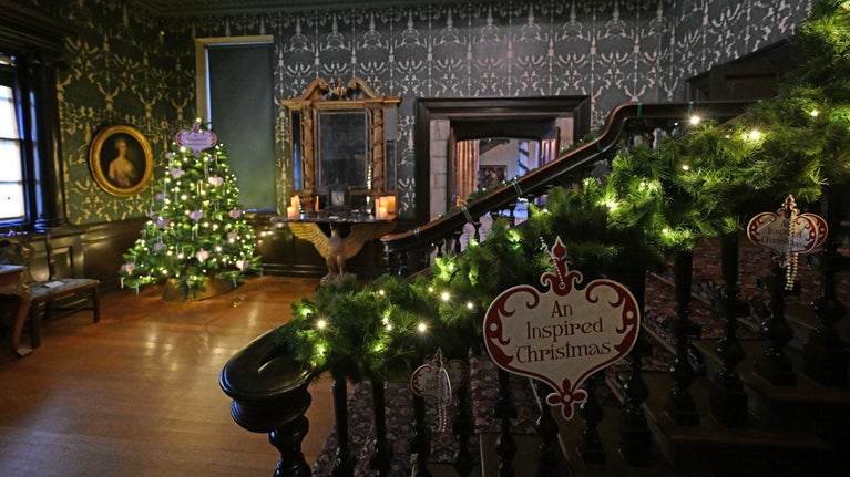 View over a decorated banister in a grand hallway with a Christmas tree and decorations.